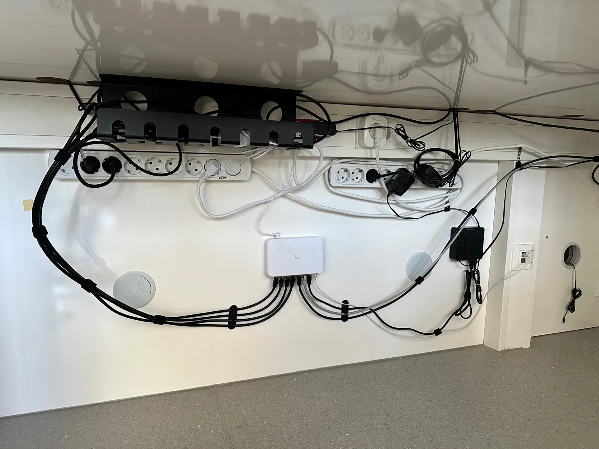 Nachher: dieselbe Anmeldung. UniFi Switch an der Wand, Netzteile in der Kabelwanne, jedes Kabel gebündelt und geführt.